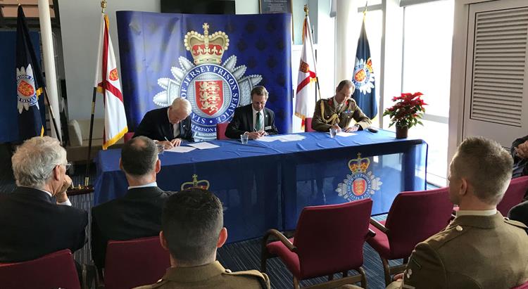 A grou of people watch the signing of the UK Armed Forces Covenant 