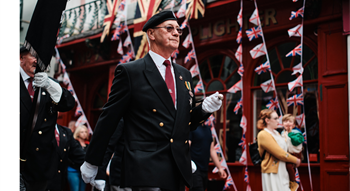 Man marching with flags in the background