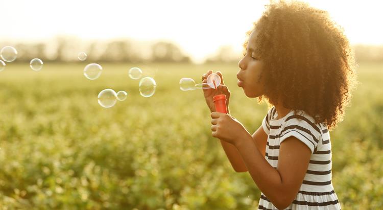 A girl blows bubbles