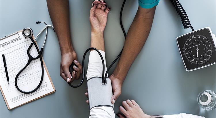 A doctor or nurse takes a blood pressure reading