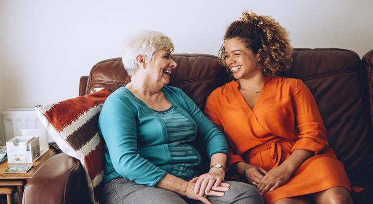 Two smiling people sitting on a couch